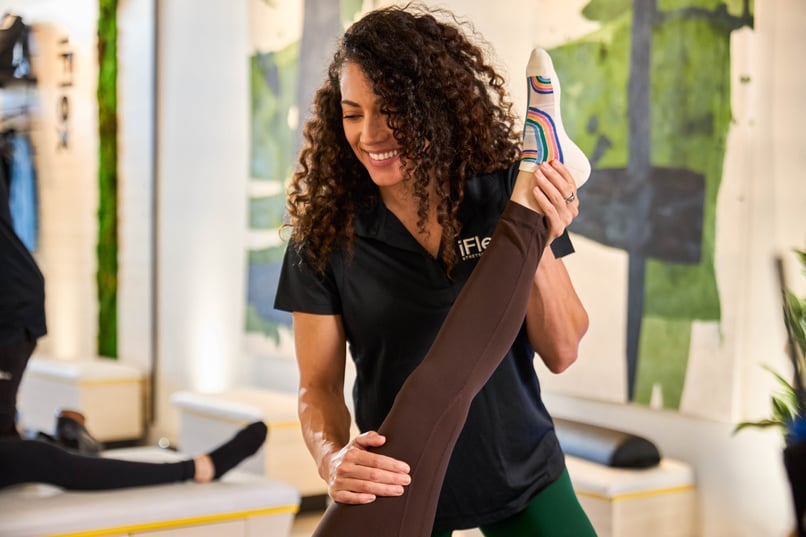 iFlex Stretch Specialist guiding a client through an assisted hamstring stretch