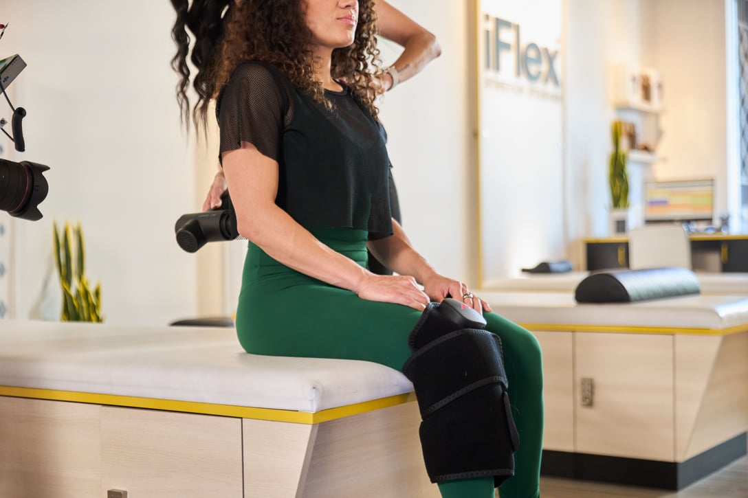 Client relaxing in Normatec compression boots at iFlex