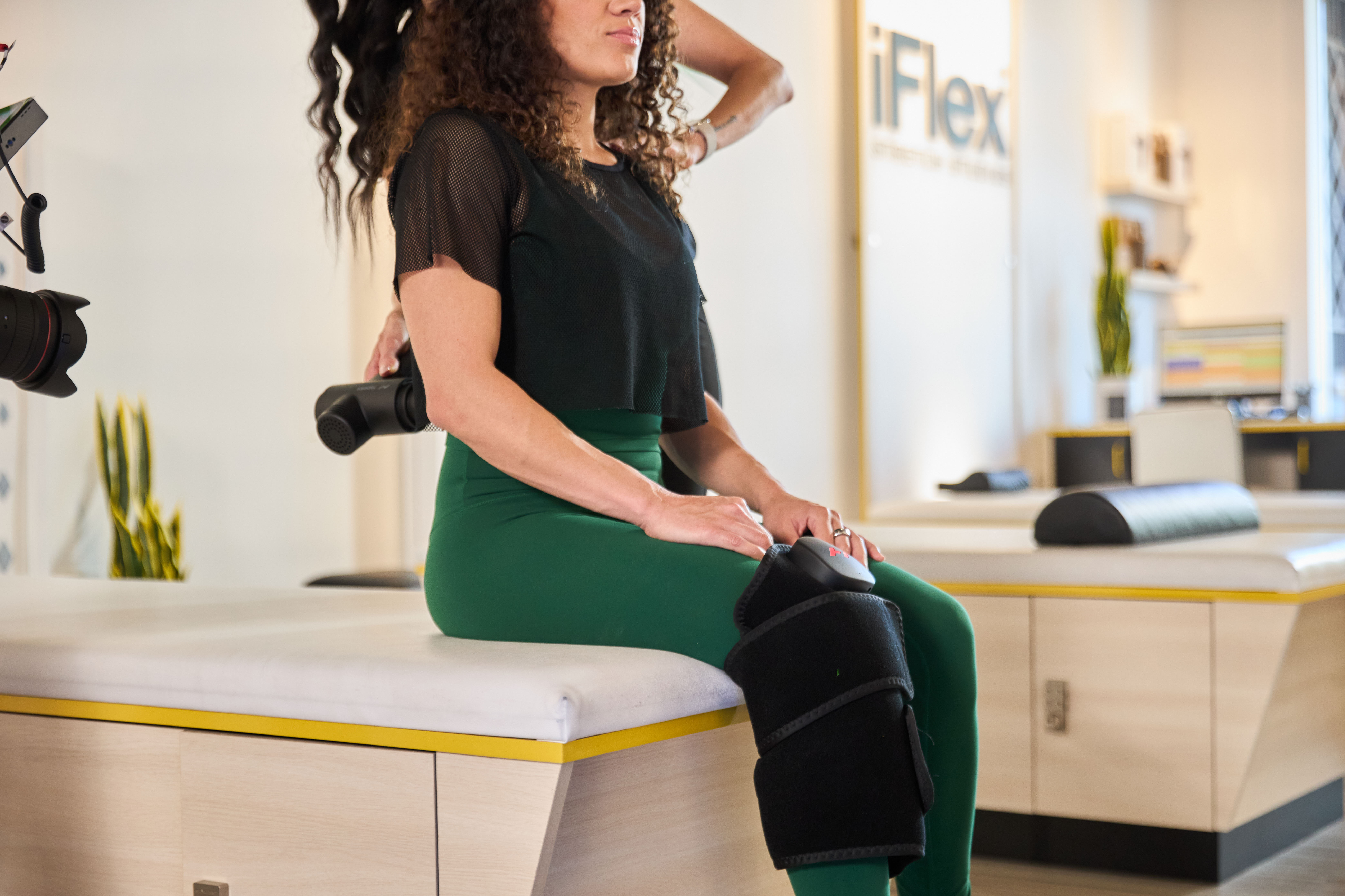 woman using hyperice during iFlex assisted stretch session