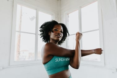 Young woman performing an upper body stretch as a mobility exercise